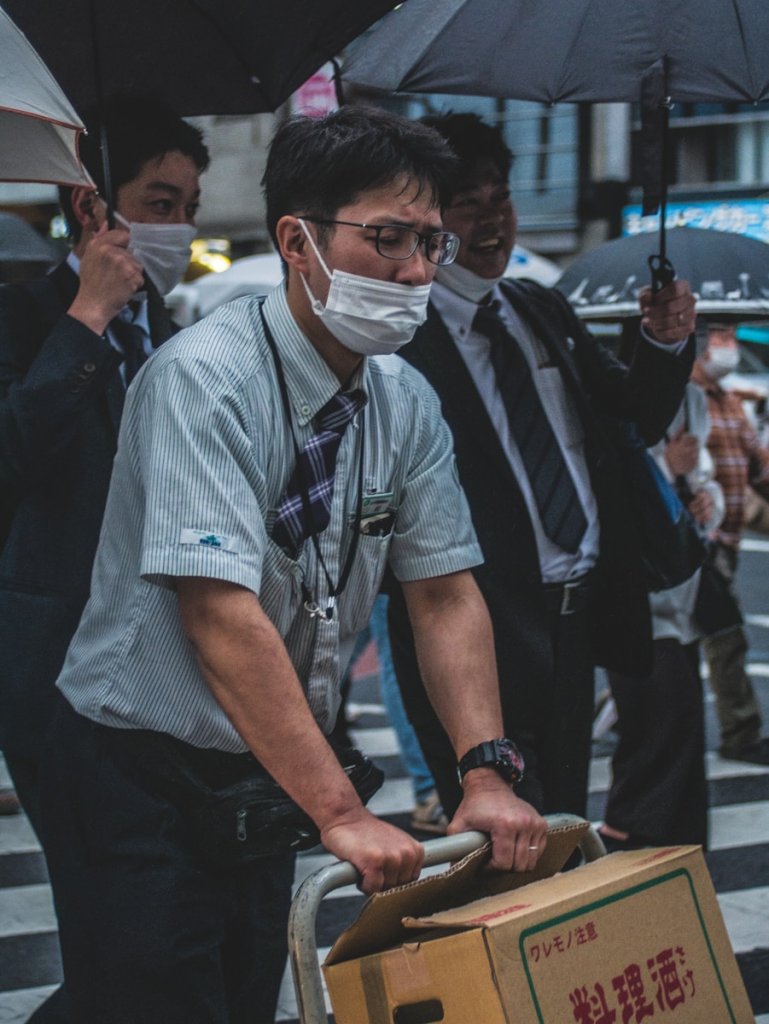 a man wearing a face mask and carrying a suitcase