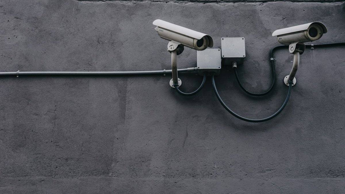 two bullet surveillance cameras attached on wall